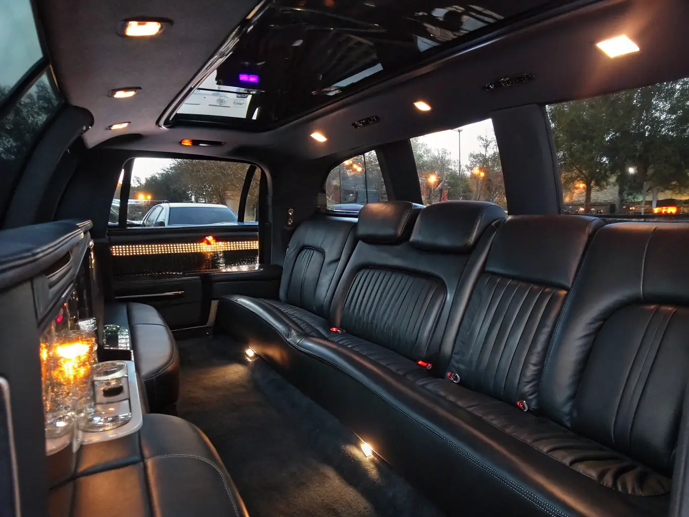 A luxurious VIP vehicle with leather seats, tinted windows, and advanced entertainment systems, parked in front of a high-end hotel, representing Alkandar Tourism's premium transportation services for discerning clients.